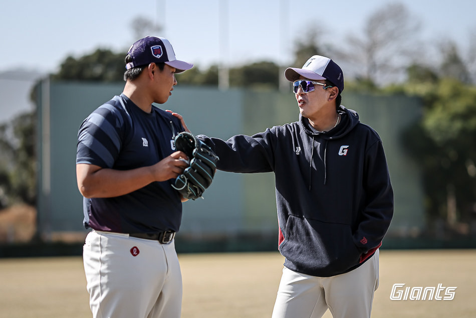 롯데 박진(왼쪽)이 지난달 22일 일본 미야자키 난고스타디움서 열린 세이부와 연습경기를 앞두고 이재율 불펜코치와 대화하고 있다. 사진제공|롯데 자이언츠
