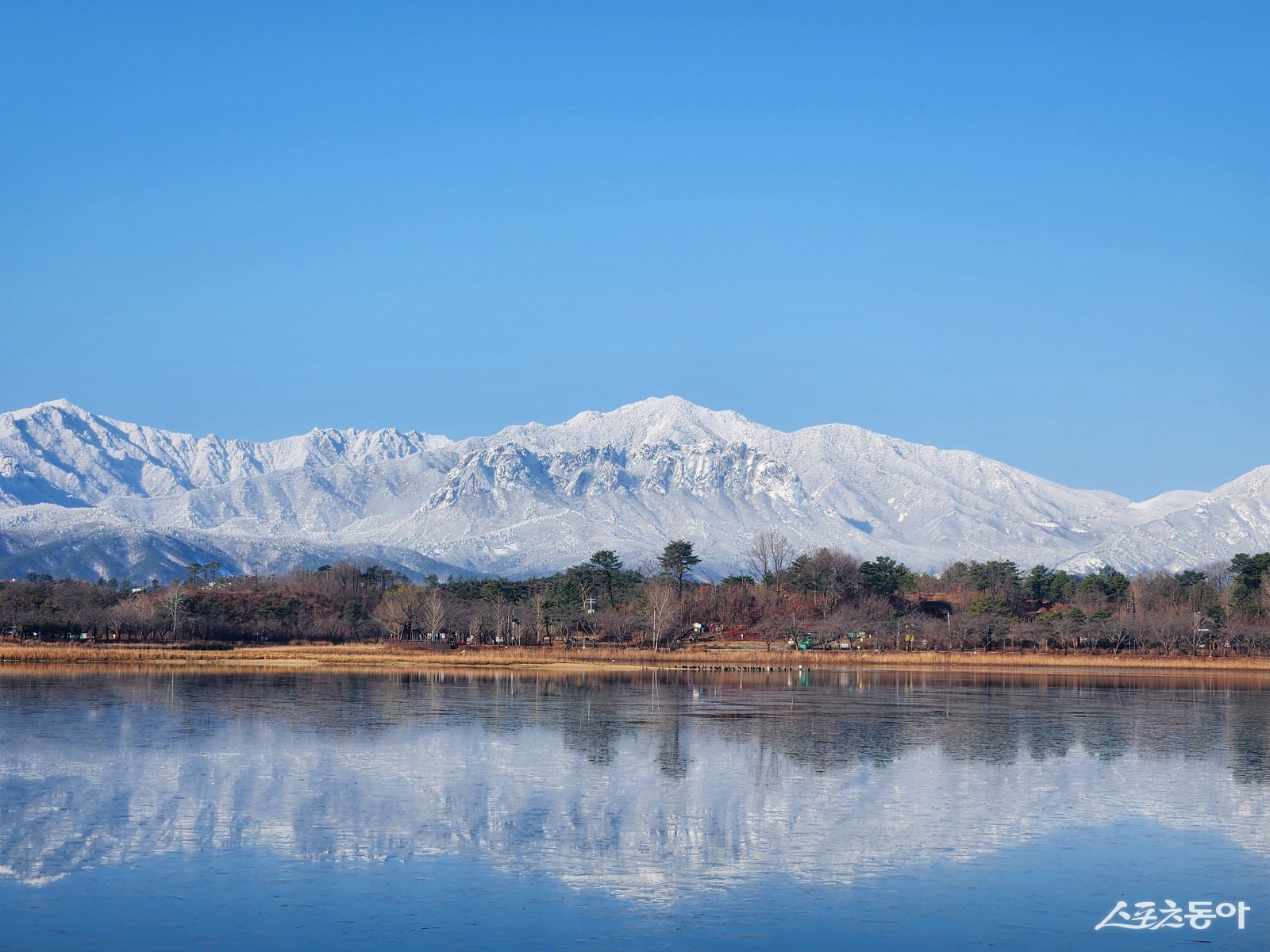 눈덮인 설악산을 배경으로 한 영랑호 설경. 속초시 제공
