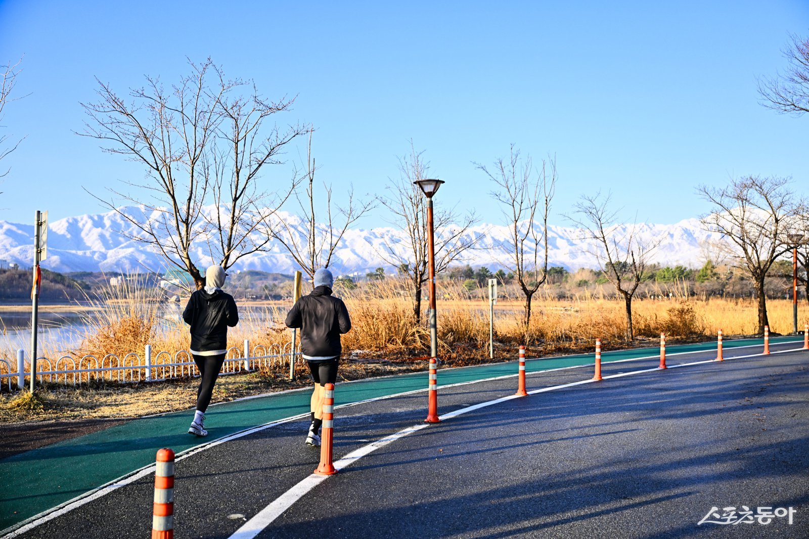 눈 내린 설악산 배경으로 영랑호에서 아침 운동 중인 시민들. 속초시 제공