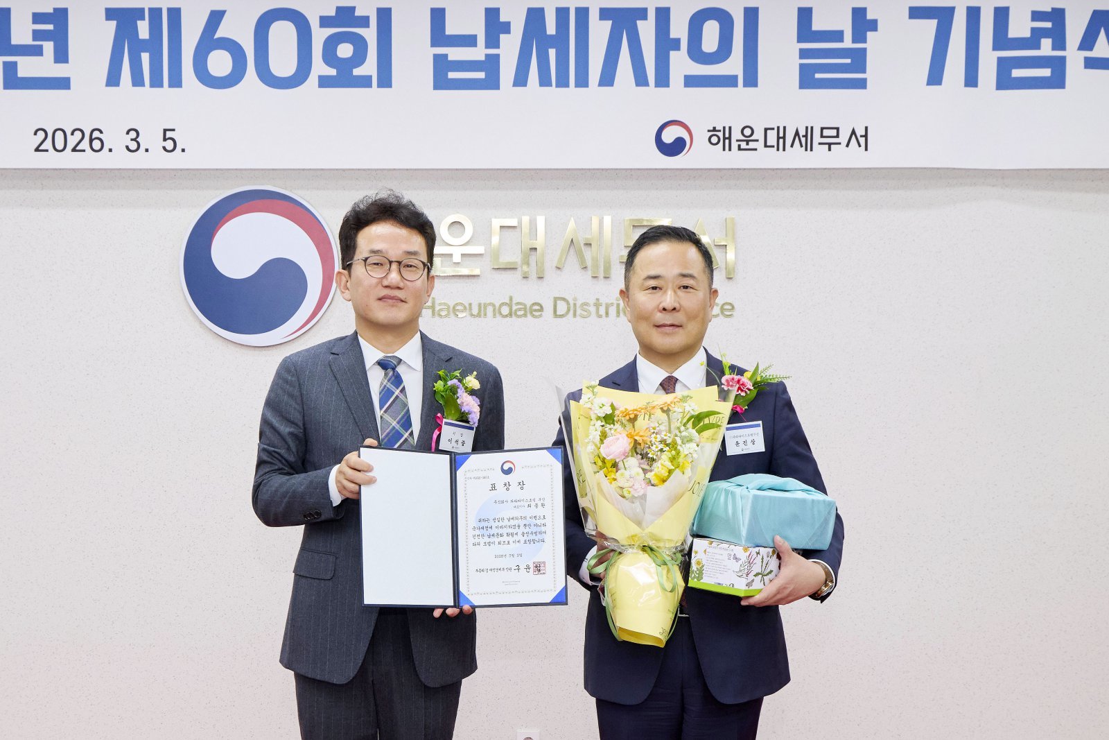 파라다이스 호텔 부산 윤진상 총지배인(오른쪽)과 이석중 해운대세무서장이 납세자의 날 기념식에서 기념촬영을 하고 있다.