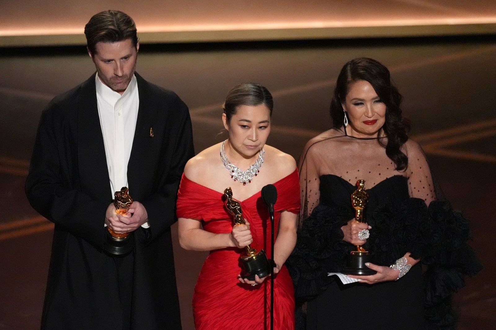 Chris Appelhans, from left, Maggie Kang, and Michelle L.M. Wong accept the award for animated feature film for “K-pop Demon Hunters” during the Oscars on Sunday, March 15, 2026, at the Dolby Theatre in Los Angeles. (AP Photo/Chris Pizzello)