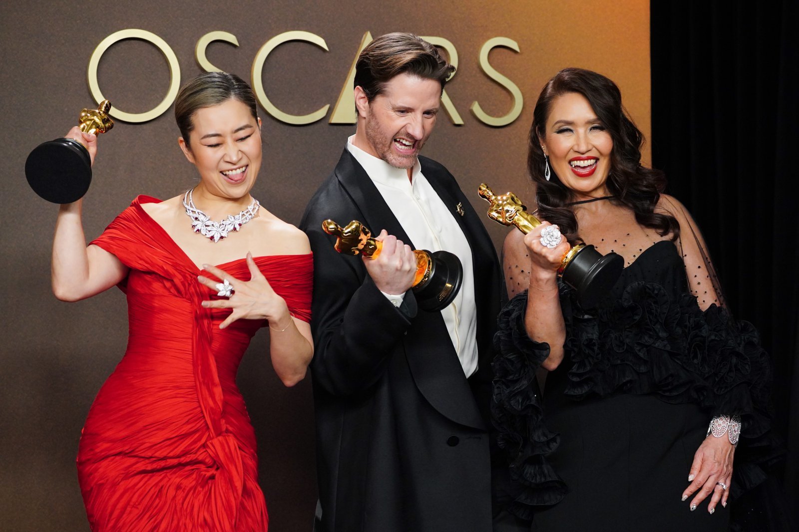 Maggie Kang, from left, Chris Appelhans, and Michelle L.M. Wong, winners of the award for animated feature film for “K-pop Demon Hunters,” pose in the press room at the Oscars on Sunday, March 15, 2026, at the Dolby Theatre in Los Angeles. (Photo by Jordan Strauss/Invision/AP)