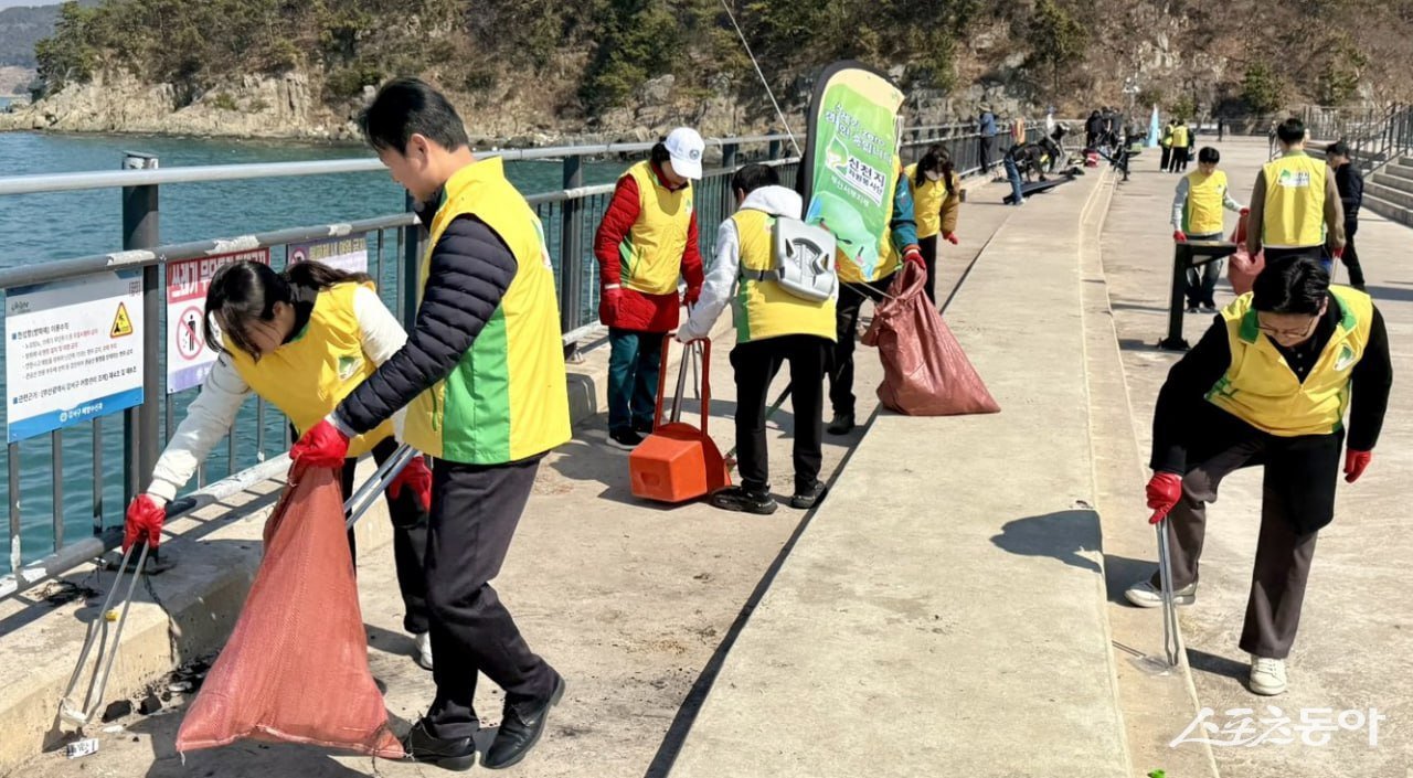 지난 23일 가덕도 천성항에서 ‘자연아 푸르자’ 캠페인을 진행하는 가운데 봉사자들이 쓰레기를 수거하고 있다. (사진제공 = 신천지자원봉사단 부산서부지부)