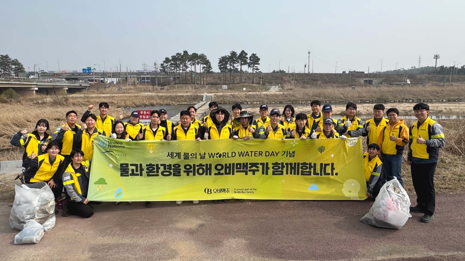 오비맥주 이천공장 임직원이 이천 복하천 일대에서 환경 정화 활동을 마치고 기념사진을 찍고 있다. 사진제공 ｜오비맥주