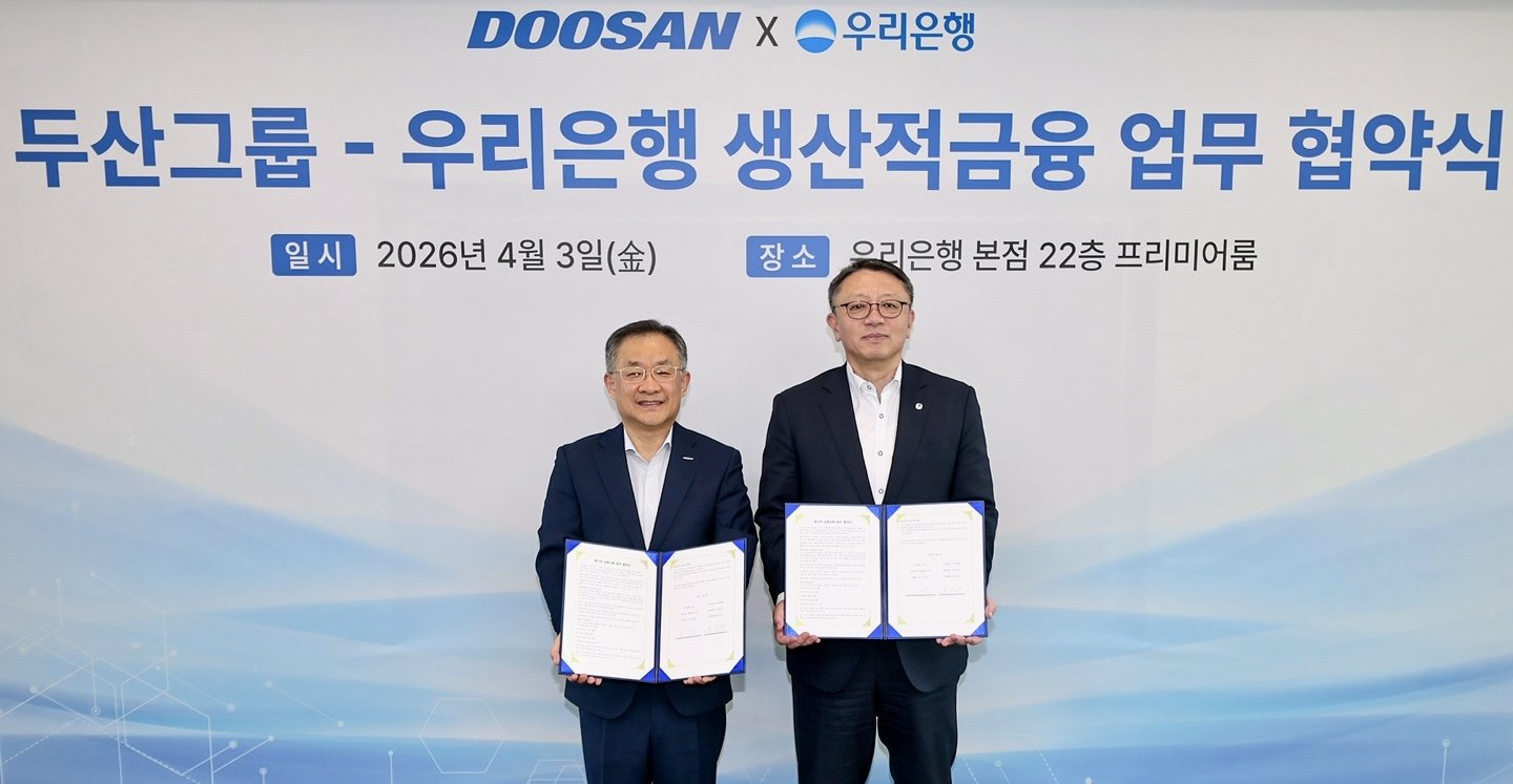 협약식 후 기념촬영을 하고 있는 정진완 우리은행장(오른쪽)과 김민철 두산 사장. 사진제공｜우리은행