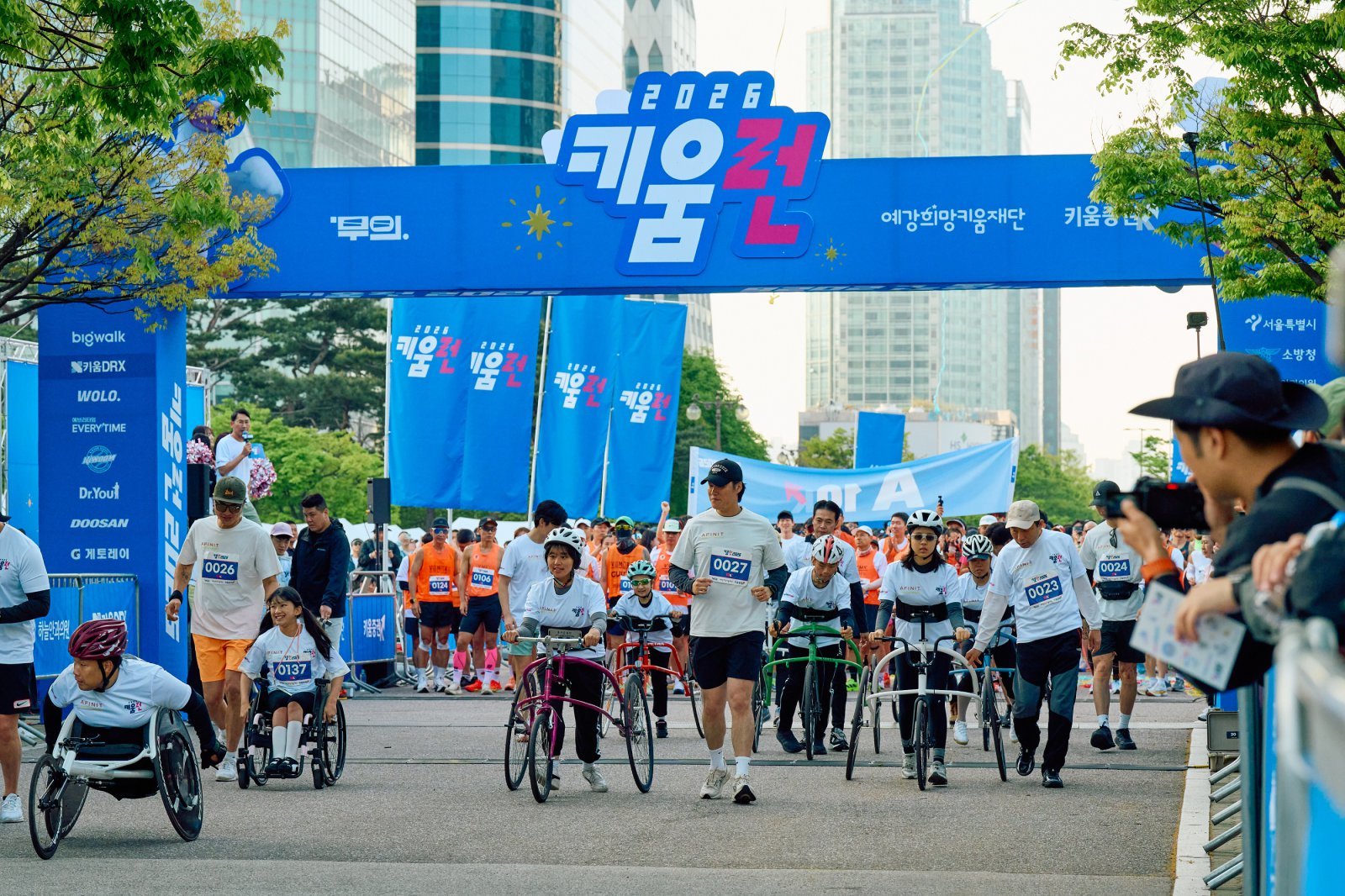 장애인·비장애인 단축마라톤 ‘키움런’에서 참가자들과 기념 촬영을 하고 있는 엄주성 키움증권 대표, 홍윤희 무의 이사장(왼쪽에서 1·2번째), 박상조 예강희망키움재단 대표(맨 오른쪽). 아래 사진은 키움런 출발 모습. 사진제공|키움증권