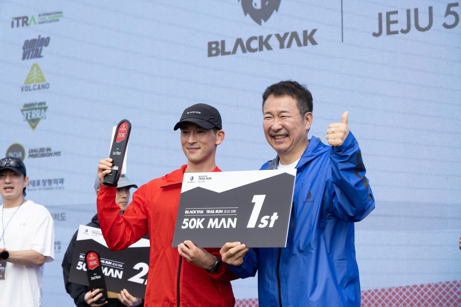‘블랙야크 트레일 런 제주 50K’에서 50K부문 1위를 차지한 이규호 선수(좌)가 블랙야크 BY사업본부장 김익태 사장(우)과 기념촬영을 하고 있다