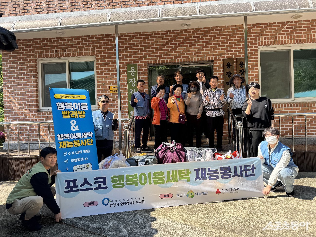 포스코 광양제철소 에너지부 봉사단이 용장마을에서 ‘행복이음 빨래방’ 재능나눔 봉사활동을 펼치고 기념촬영을 하고 있다. 사진제공=광양시