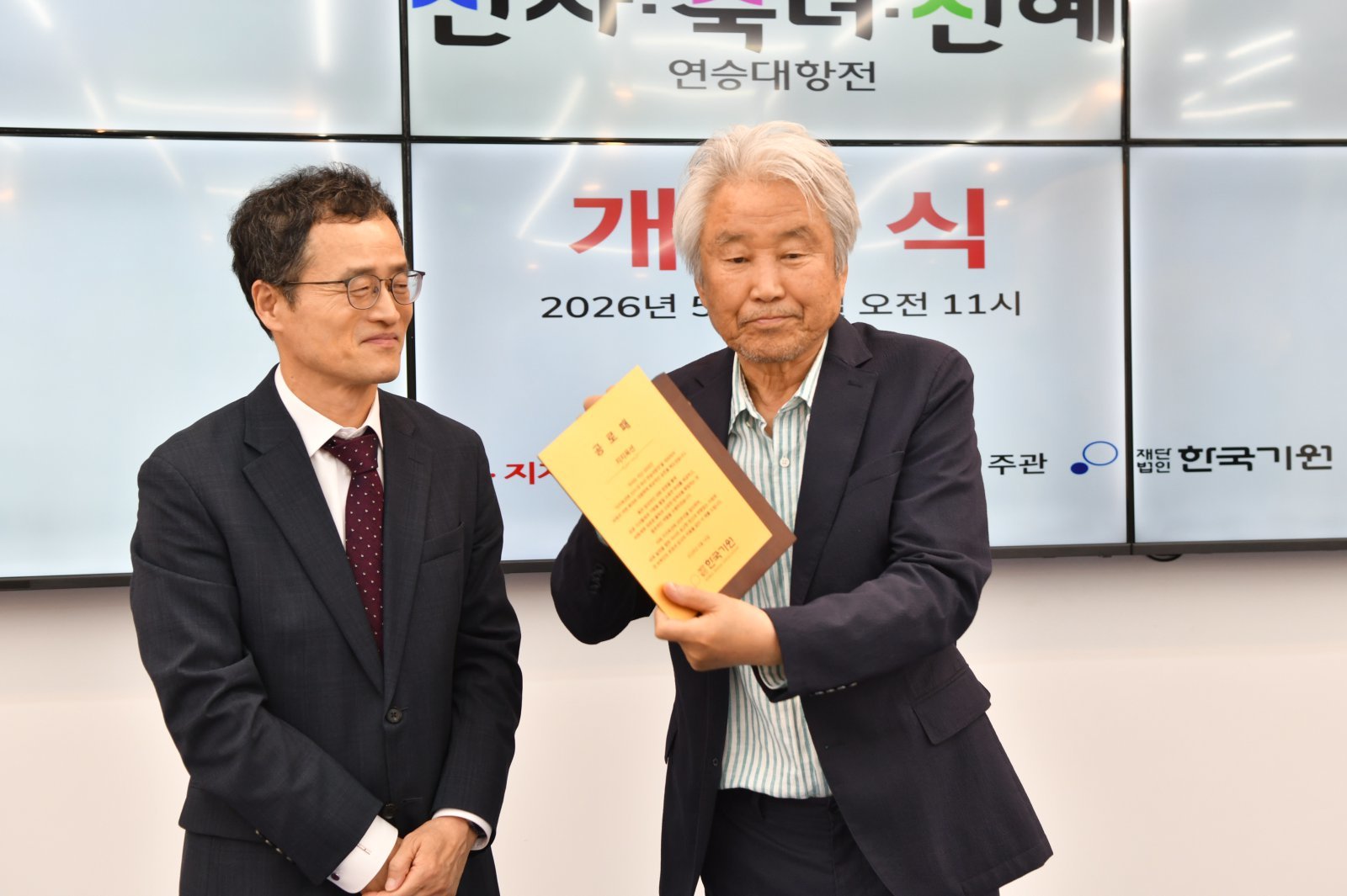 한국기원 양재호 사무총장으로부터 공로패를 전달받은 강명주 지지옥션 회장(오른쪽). 시진제공 한국기원