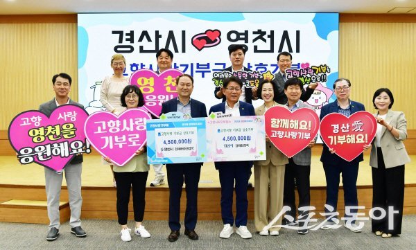 경산시 경제환경국과 영천시 경제환경산업국이 고향사랑기부제 퍼포먼스를 하고 있다. 사진제공 ㅣ 경산시