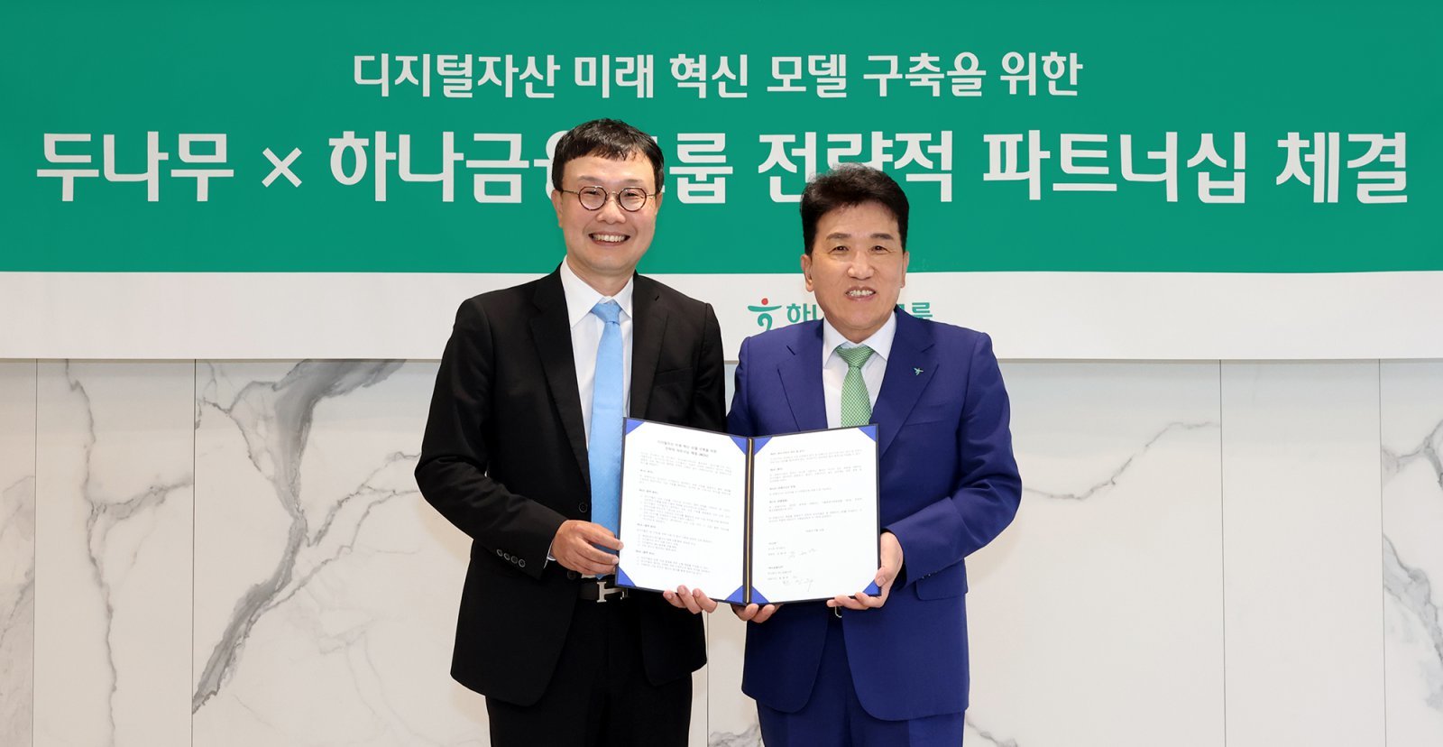 ‘금융·디지털자산 연계 미래혁신모델 구축’을 위한 전략적 업무협약 후 기념 촬영을 하고 있는 함영주 하나금융 회장(오른쪽)과 김형년 두나무 부회장. 사진제공｜하나금융