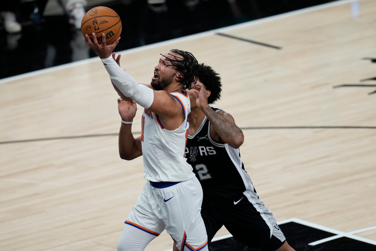 닉스 제일런 브런슨(왼쪽)이 4일(한국시간) 프로스트뱅크센터에서 열린 2025~2026 NBA 파이널 1차전 샌안토니오 원정경기 도중 레이업슛을 시도하고 있다. 샌안토니오｜AP뉴시스