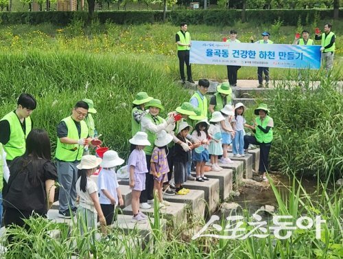 김천시 율곡동이 지역 어린이들과 함께 토종어류를 방류하고 있다. 사진제공 ㅣ 김천시