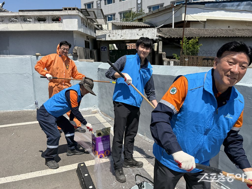 포스코PHP봉사단 임직원들이 지난 11일 광양 YWCA 무료급식소 주변의 환경 개선을 위해 노후된 골목길 담벼락에 푸른색 페인트를 칠하며 도색 작업을 하고 있다. 사진제공=광양제철소