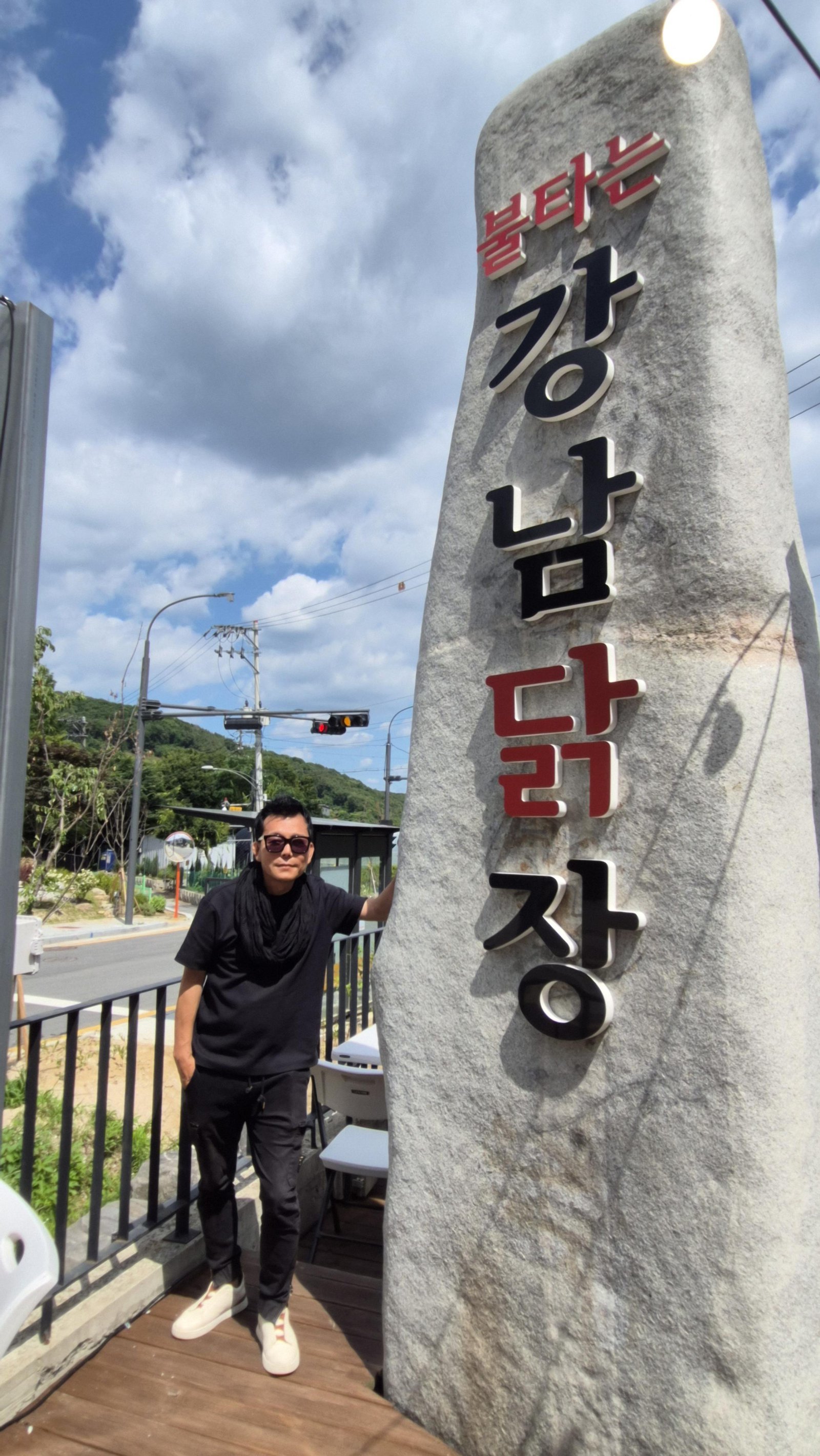 매장 앞 대형 돌간판과 포즈를 취한 석현수 회장.