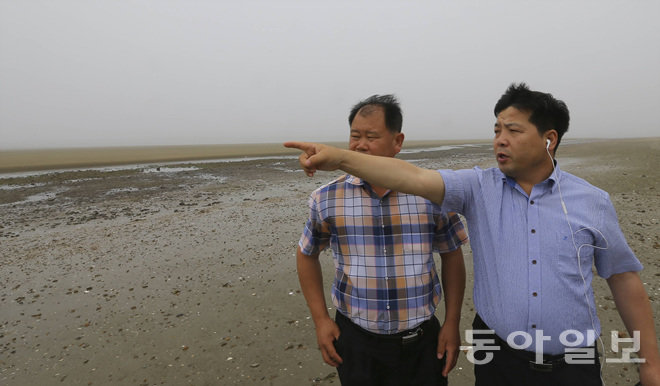 ‘태안 사설 해병대 캠프 참사’의 유족 이후식 씨(고 이병학 군 아버지·왼쪽)와 김영철 씨(고 김동환 군 아버지·오른쪽 앞)가 14일 사고 해변을 찾았다. 유족들은 “모래들이 움푹 파인 것은 인근 해수욕장으로 모래를 나르는 불법공사 때문에 생겼다”고 강조했다. 태안=원대연 기자 yeon72@donga.com