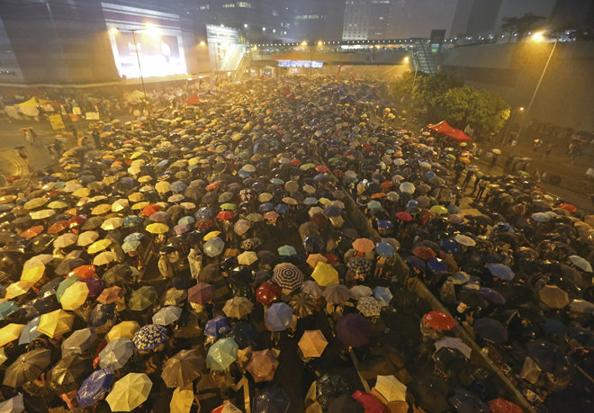 30일 밤 홍콩 중심가에 갑자기 폭우가 쏟아지자 정부청사 인근 도로에 모인 시위대가 일제히 우산을 펼쳐들고 집회를 강행하고 있다. 홍콩=AP 뉴시스