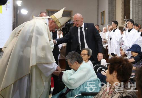 ‘평화와 화해를 위한 미사’ 집전을 위해 서울 명동대성당 본당에 들어온 프란치스코 교황이 일본군 위안부 피해자인 길원옥 할머니의 손을 잡고 위로하고 있다. 이날 미사에는 7명의 위안부 할머니가 참석했다. 신원건　기자　laputa@donga.com