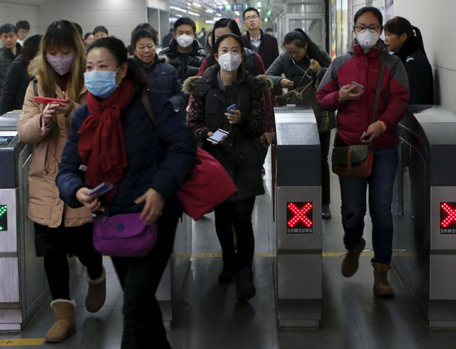 사상 처음으로 스모그 적색경보가 발령된 첫날인 8일 중국 베이징 시민들이 두꺼운 마스크를 쓰고 지하철 개찰구를 나오고 있다. 베이징=로이터 뉴스