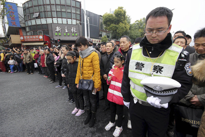 13일 오전 10시 중국 장쑤 성 난징에서 사이렌이 울리자 길 가던 시민들이 멈춰 선 채 묵념을 하고 있다. 이날 난징 대학살 78주년을 맞아 열린 추모식에는 1만여 명이 참가해 30만 희생자의 넋을 기렸다. 난징=로이터 뉴스1
