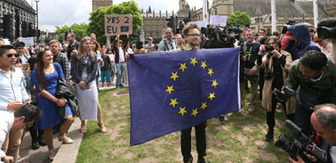 브렉시트’에 반대하는 한 영국 시민이 25일 런던의 웨스트민스터(국회의사당) 인근 의회광장에서 유럽연합(EU) 상징기를 들고 시위하고 있다. 브렉시트 재투표를 요구하는 청원에 300만 명 이상이 서명하는 등 영국의 EU 탈퇴 결정에 반발하는 움직임이 확산되고 있다. 런던=AP 뉴시스