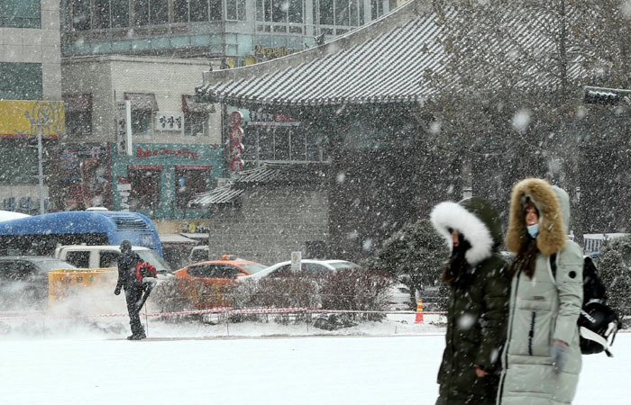 매서운 한파가 이어지는 가운데 13일 오전 서울광장에서 한 인부가 내린 눈을 바람으로 치워 시민들의 보행로를 만들고 있다.  변영욱기자 cut@donga.com