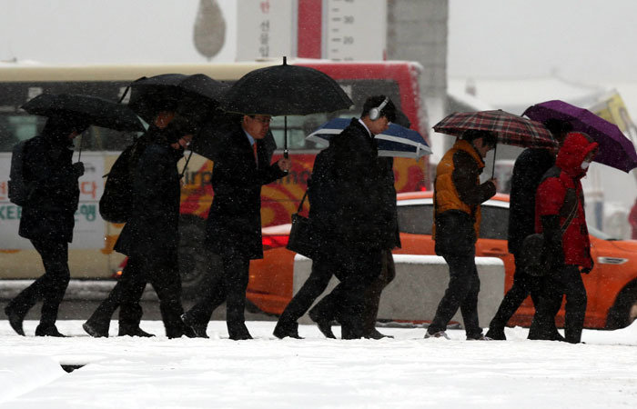 밤사이 많은 눈이 내린 20일 오전 서울 종로구 광화문네거리 인근에서 시민들이 출근을 하고 있다. 최혁중 기자 sajinman@donga.com