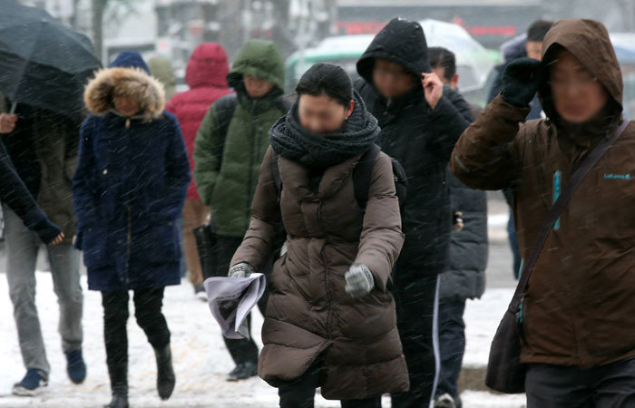 밤사이 많은 눈이 내린 20일 오전 서울 종로구 광화문네거리 인근에서 시민들이 출근을 하고 있다. 최혁중 기자 sajinman@donga.com